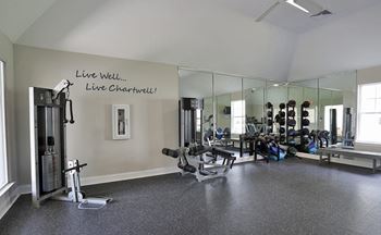 A gym with a mirrored wall and a motivational quote.